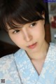 A woman in a blue and white kimono poses for a picture.