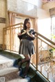 A woman in a school uniform is standing on the stairs.